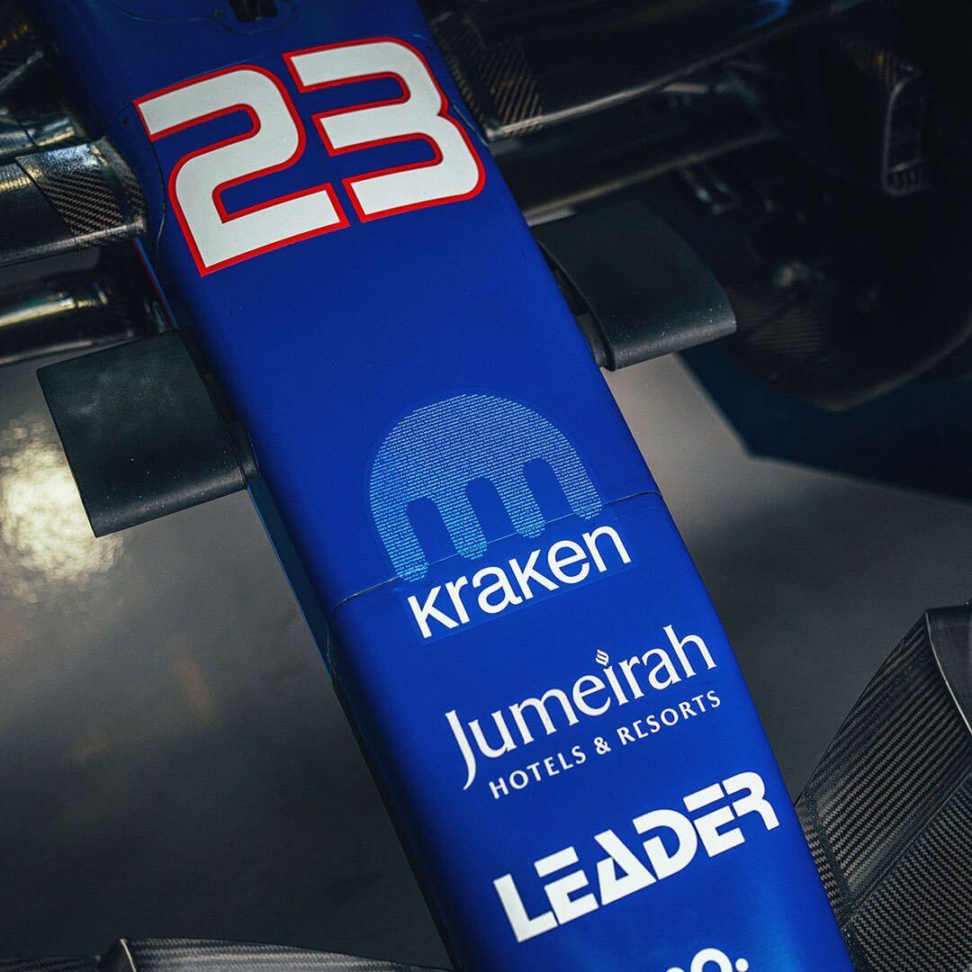 За что подали в суд на Kraken. Текст вайтпейпера Биткоина в эмблеме Kraken на болиде Формулы-1. Фото.