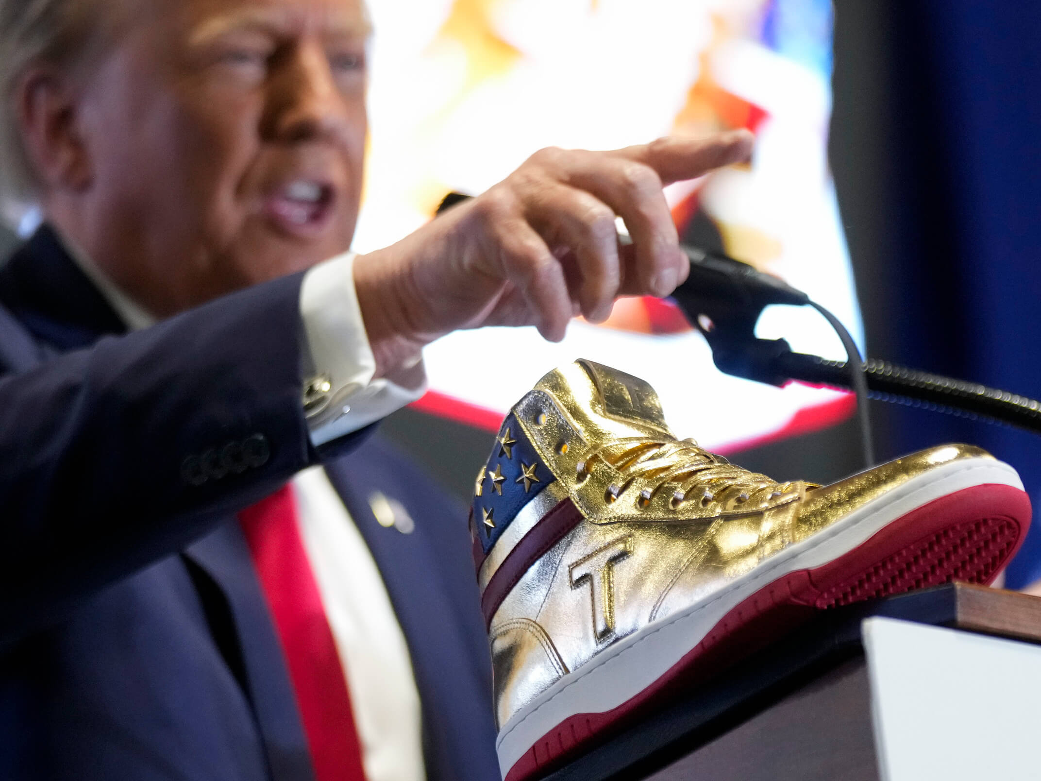 Кто поддерживает Биткоин. Дональд Трамп во время презентации своих кроссовок. Фото.
