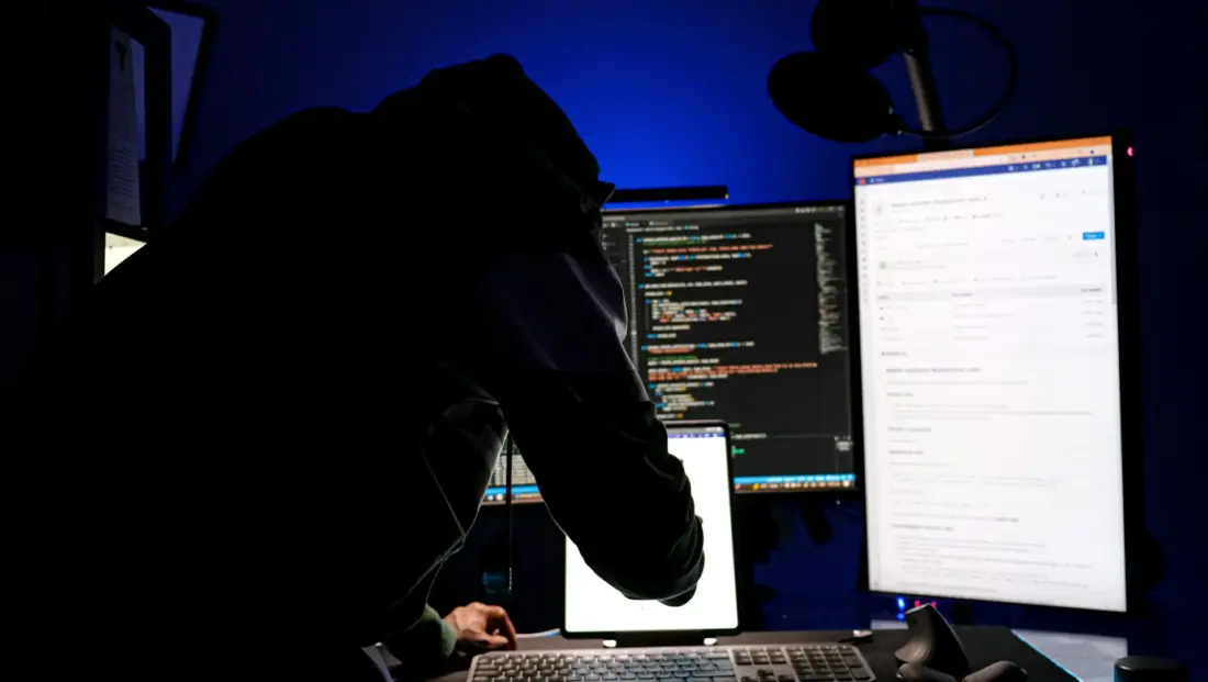 Cold hardware crypto wallet on dark background with lines of code reflected on screen