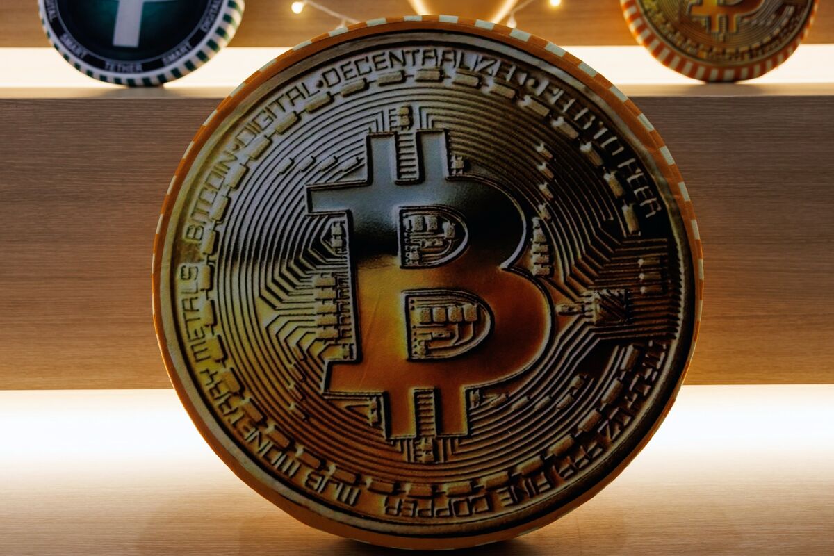 Физическая монета Bitcoin с символом биткоина на деревянной поверхности