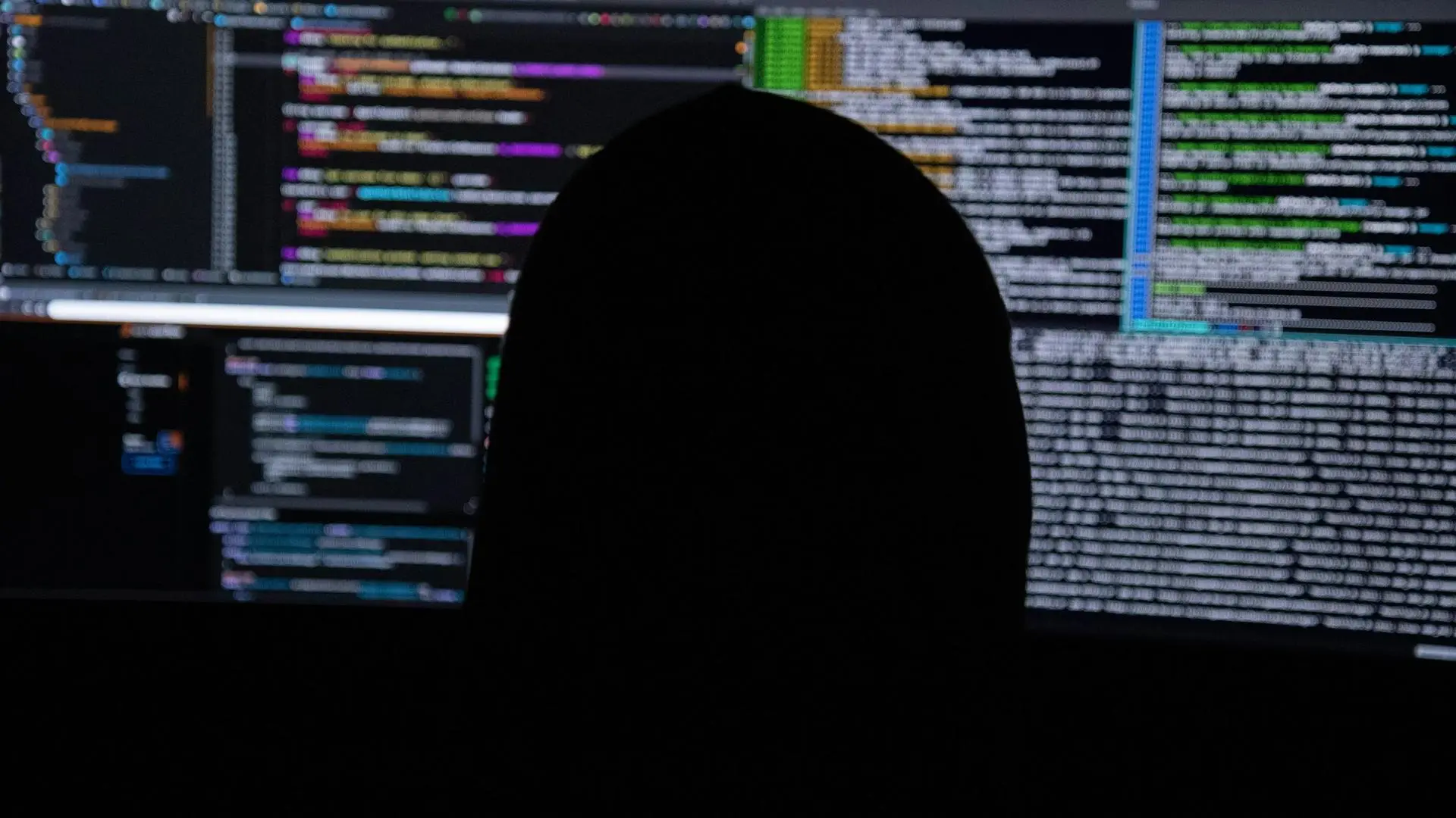 Разработчик работает с кодом на мониторах