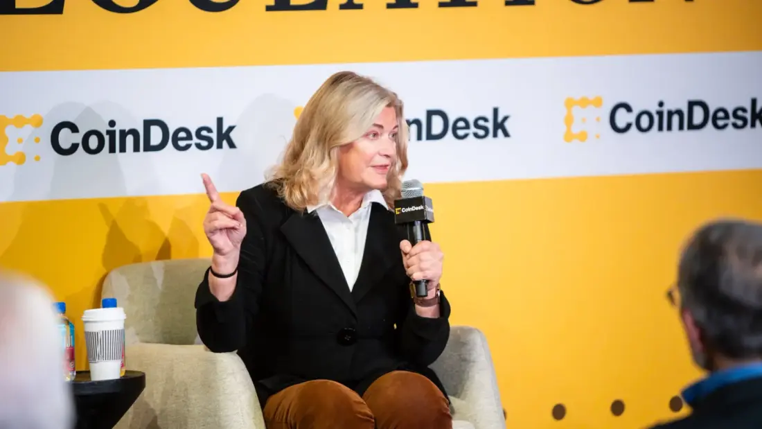 Спикер выступает на конференции CoinDesk с микрофоном