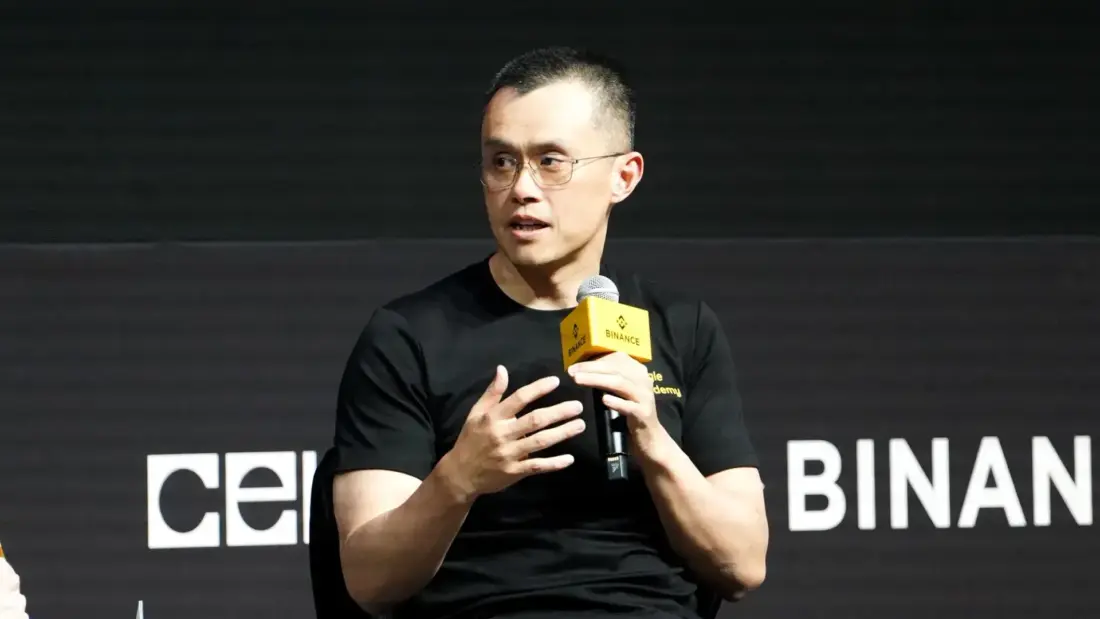 Представитель Binance выступает на конференции с микрофоном